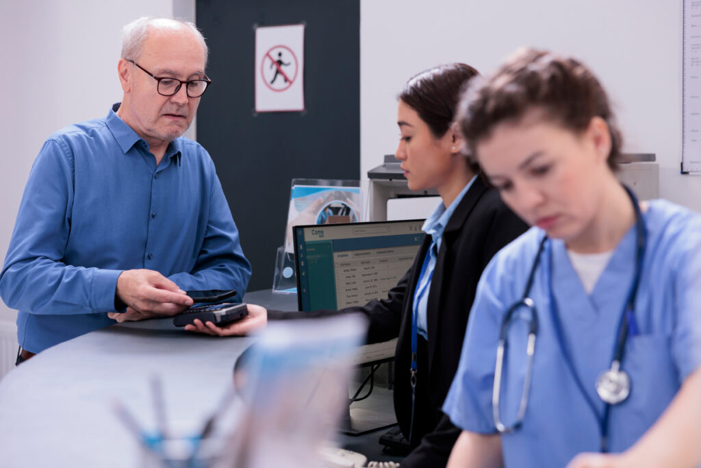 A patient receives information at a hospital front desk.